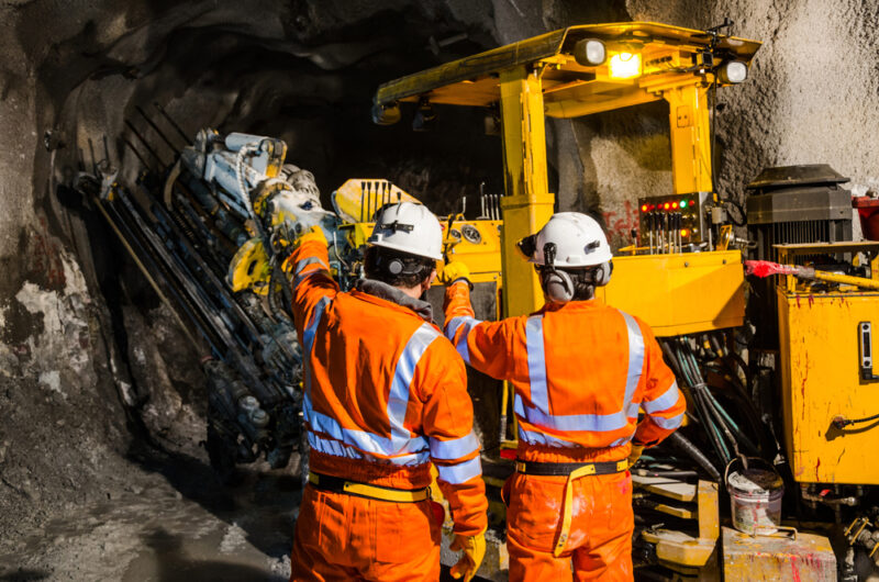 Mine workers operating an underground drill.