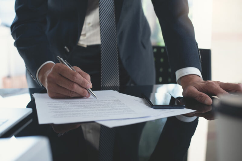 Business man signing paperwork.